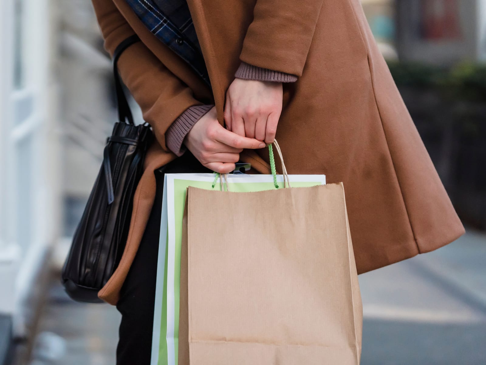 A shopper browsing products on a phone in a bright retail space